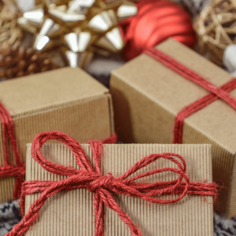 Wrapped gift boxes with red twine and festive decorations, symbolizing holiday spirit and community engagement in Advancio's news updates.